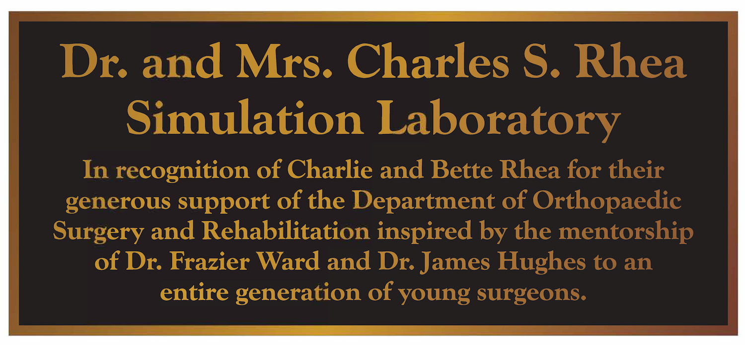 Plaque that reads, Dr. and Mrs. Charles S. Rhea Simulation Laboratory. In recognition of Charlie and Bette Rhea for their generous support of the Department of Orthopaedic Surgery and Rehabilitation inspired by the mentorship of Dr. Frazier Ward and Dr. James Hughes to an entire generation of young surgeons.